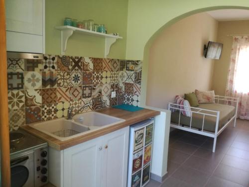 a kitchen with a sink and a couch in a room at Kallisti Seaside Studios Skopelos in Agnontas