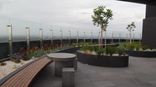 a balcony with a bench and plants on a building at Whitehorse Towers Self Service Holiday Apartment in Box Hill