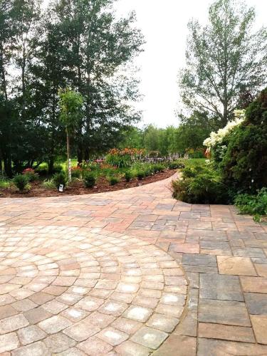 a brick walkway in a garden with trees and flowers at Briarwood Bed & Breakfast in Elmsdale