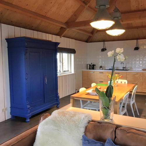 a living room with a blue cabinet and a table at Groeten uit Hoogmade - rural cottage in Hoogmaden