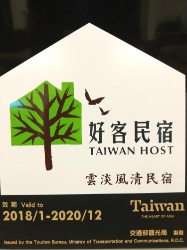 a sign with a tree and a bird at Home-Link B&B in Fenglin