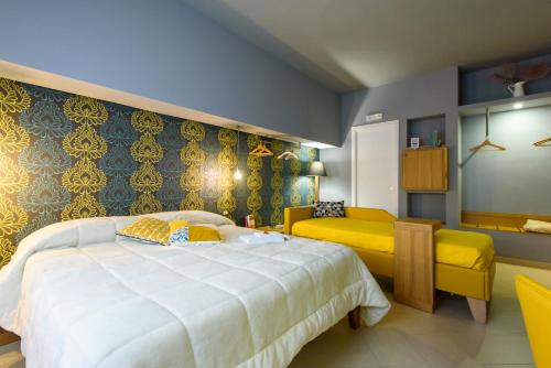 エンナにあるUn B&B al Belvedereのベッドルーム(大型ベッド1台、黄色いソファ付)