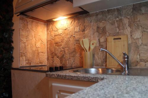 a kitchen with a sink and a stone wall at Invicta Flats - Oporto in Porto