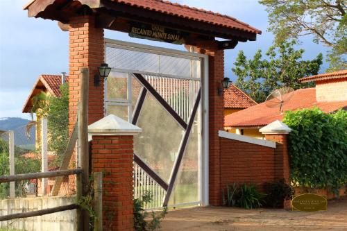 une maison en briques avec une grande porte en verre dans l'établissement Chalé Recanto Monte Sinai, à Piracaia