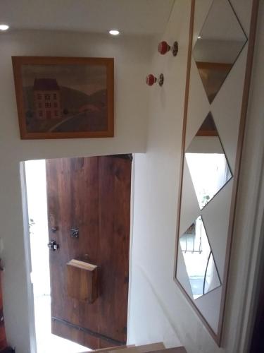 La salle de bains est pourvue d'une porte en bois et d'un miroir. dans l'établissement Studio à 2 pas du Palais, à Cannes