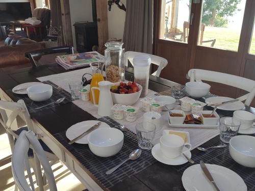 a table with plates and bowls of food on it at Cromwell Lakeside B n B in Cromwell