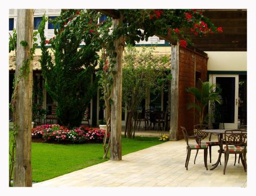 an outdoor patio with a table and chairs and flowers at Don Quixote Pousada in Tiradentes