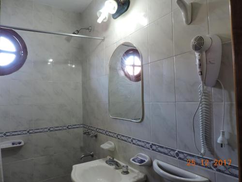 een badkamer met douche, wastafel en spiegel bij Inti Duplex in San Bernardo