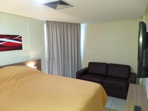 Habitación de hotel con cama y sofá en AP 306 Flat Beira mar praia de Tambaú, en João Pessoa