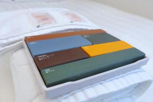 a stack of books sitting on top of a bed at Tiin Tinn - Rivershore B&B in Taitung City