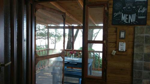 a door to a porch with a table on a deck at COEMBOTA Cabañas in Tigre