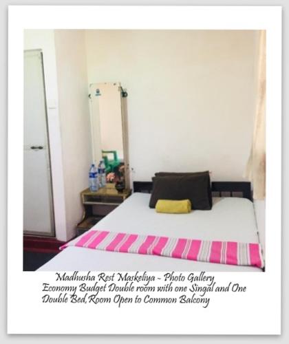 a picture of a bedroom with a bed with a mirror at Madhusha Rest in Maskeliya