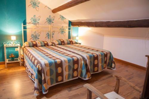 a bedroom with a bed with a colorful bedspread at Casa Rural La Cenicienta in Sancti Spíritus