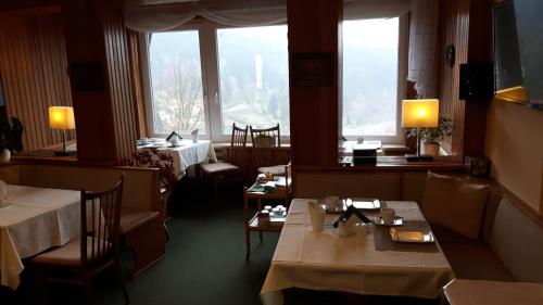 a restaurant with two tables and a view of the city at Pension Talblick Bad Grund in Bad Grund