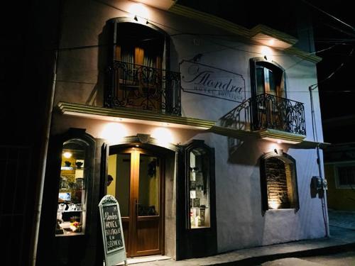 a restaurant with a sign on the side of a building at Alondra Hotel Boutique in Mineral del Monte