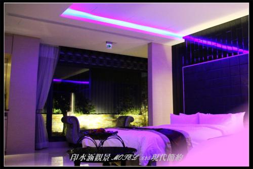 a bedroom with a bed with purple lighting at Yin Shui Han Motel in Hunei
