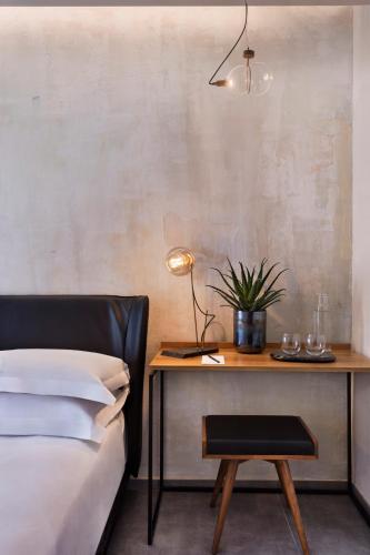 a bedroom with a bed and a desk with a lamp at The Vera in Tel Aviv