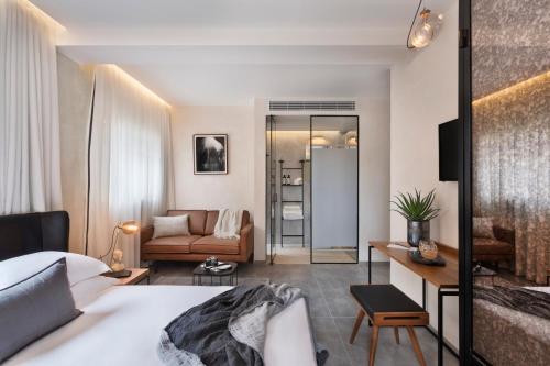 a bedroom with a bed and a living room at The Vera in Tel Aviv