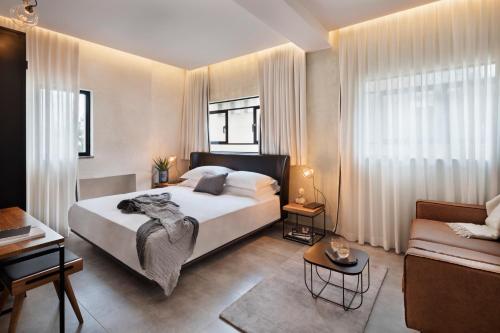 a bedroom with a large bed and a couch at The Vera in Tel Aviv