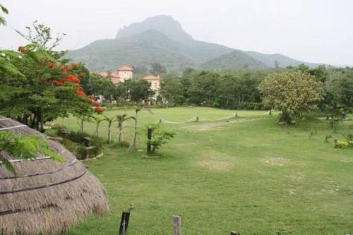 a field of grass with mountains in the background at My Chateau Resort in Kenting