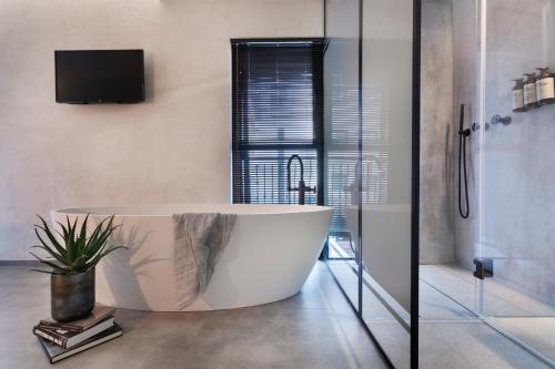 a large bath tub in a bathroom with a tv at The Vera in Tel Aviv