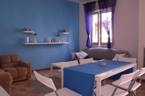 uma sala de estar azul com uma mesa e cadeiras em Naxos House em Giardini Naxos