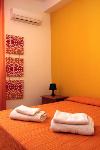 two towels sitting on top of two beds in a room at Naxos House in Giardini Naxos
