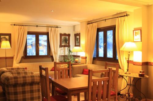 a living room with a table and chairs and a couch at Aparthotel Sarrato in Sallent de Gállego