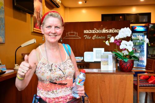 a woman giving a thumbs up while holding a bottle of water at The Choice Hotel - Adults Only in Bangkok