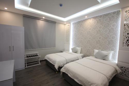 a room with two beds and a projection screen at Darin Furnished Apartments in Al Bukayriyah
