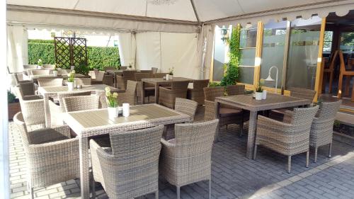 a restaurant with tables and wicker chairs at Hotel Zwei Länder in Apolda