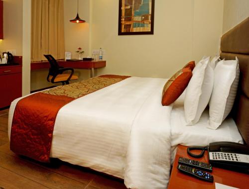 a hotel room with a large bed with pillows at Amalfi Grand in Patna