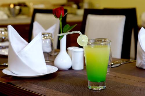 a glass of green juice sitting on a table at Amalfi Grand in Patna