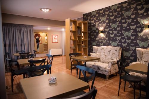 a restaurant with tables and chairs and a woman taking a picture at Hotel Maroussi in Athens