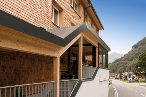 a building with a black awning next to a street at Alpine Lodge Klösterle am Arlberg in Klösterle am Arlberg