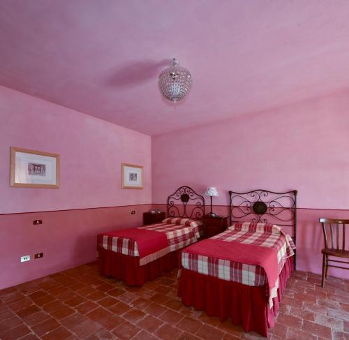 1 Schlafzimmer mit 2 Betten und rosa Wänden in der Unterkunft L'Atelier di Pierflavio Gallina in La Morra