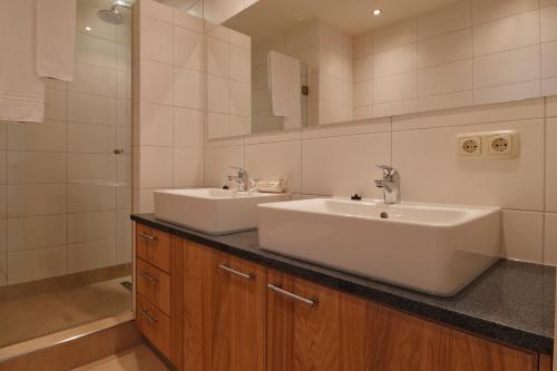 a bathroom with two sinks and a mirror at Hof van Salland Hellendoorn in Hellendoorn