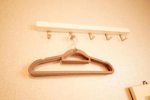 a hanger hanging on a wall with a shelf at Yeha Guesthouse in Jeju