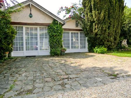a house with a stone driveway in front of it at Clos Saint Nicolas in Neauphle-le-Château