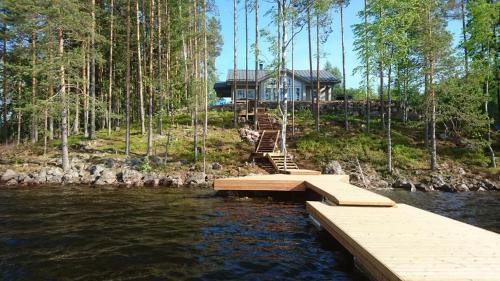 a house on the shore of a river with a dock at Villa Avanto in Suomenniemi