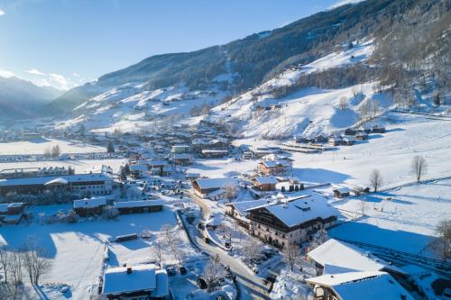 a village covered in snow with mountains in the background at Hotel Senningerbräu in Bramberg am Wildkogel