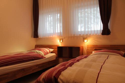 2 camas individuales en una habitación con ventana en FW "Quendorfer See" en Schüttorf