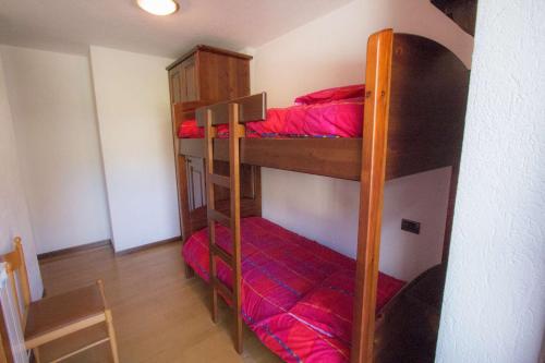 コー​​ニュにあるCasa Dina - Cogne VDA n 0020の赤いシーツを使用した二段ベッド2組が備わる客室です。