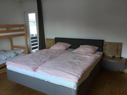 ゼルにあるWilder Kaiser Appartementのベッドルーム1室(ピンクの枕が付いたベッド1台付)
