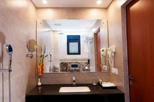 a bathroom with a sink and a large mirror at Amalfi Grand in Patna