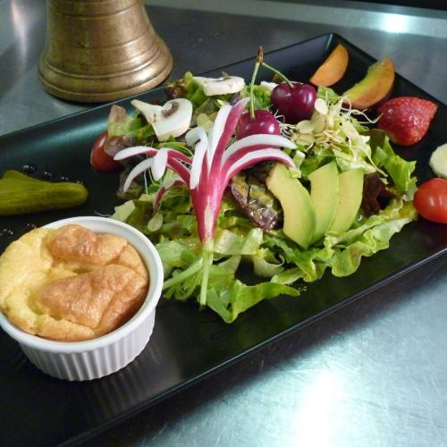une assiette noire avec une salade et un bol de nourriture dans l'établissement La Chicholiere, à Gresse-en-Vercors