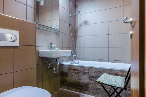 ein Badezimmer mit einem Waschbecken, einem WC und einer Badewanne in der Unterkunft Ezererdő Vendégház in Egerbakta