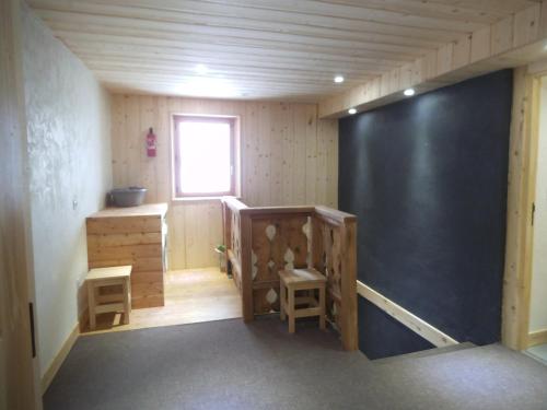 a room with two stools and a large black wall at Chalet Le Bois Joli in Bonneval-sur-Arc
