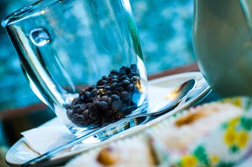 a glass jar filled with black beans on a plate at Hotel Papanikola in Piána