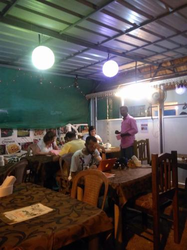 a group of people sitting at tables in a restaurant at Taj Mahal Hotel in Cochin